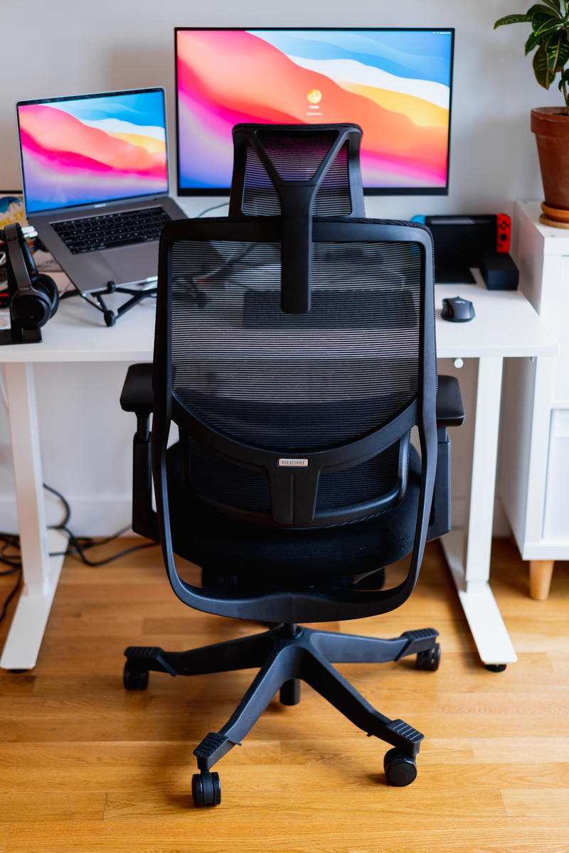 A desk chair at a desk in a home office with a monitor and a laptop.