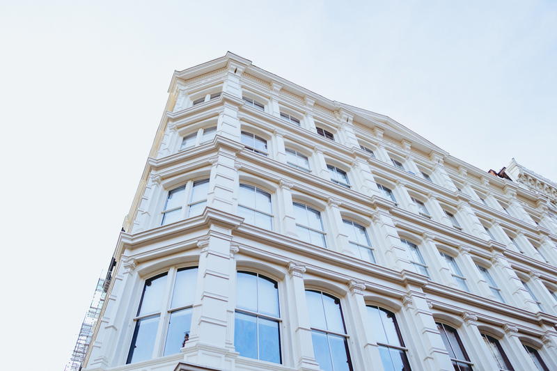A white building with a clock on top.