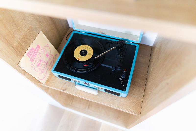 A record player is sitting on a shelf.