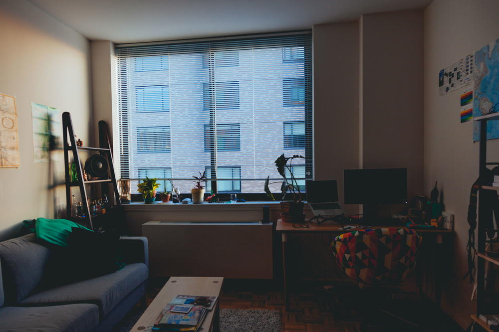 Cozy home office setup in a modern apartment with a bamboo desk, ergonomic rolly chair and external monitor set up