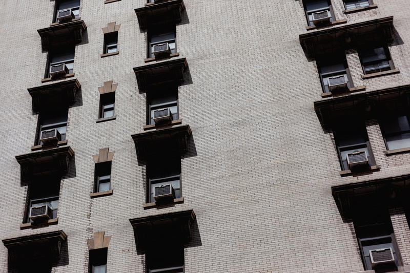 A building with a lot of windows and air conditioners.