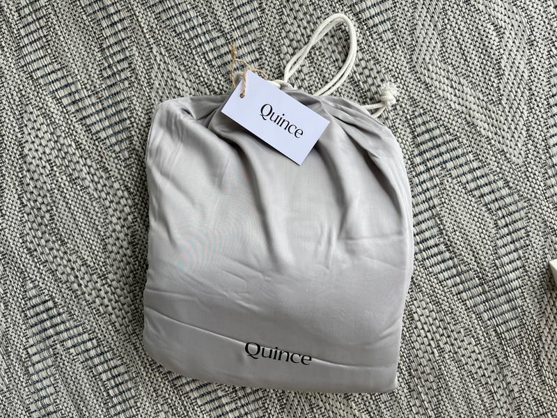 A bag with a tag on it sitting on a rug.