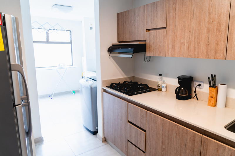 A kitchen with a refrigerator, stove and sink.