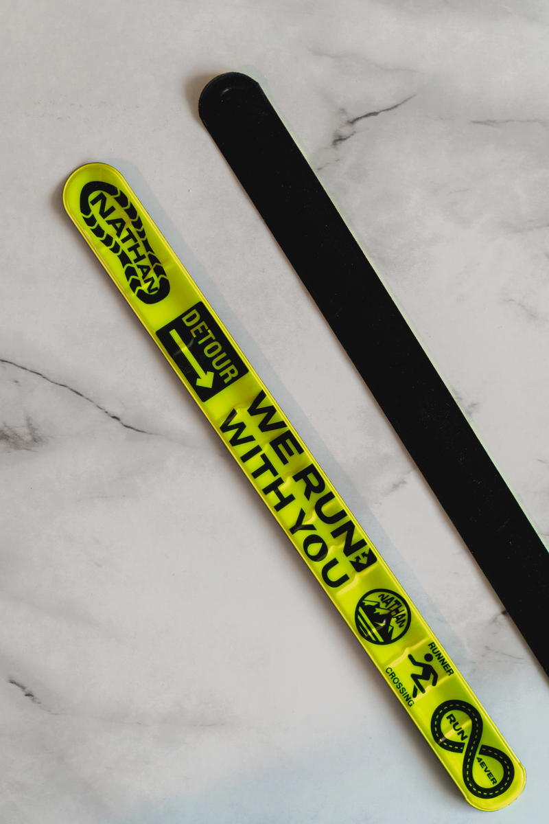 A pair of black and yellow wristbands on a marble table.
