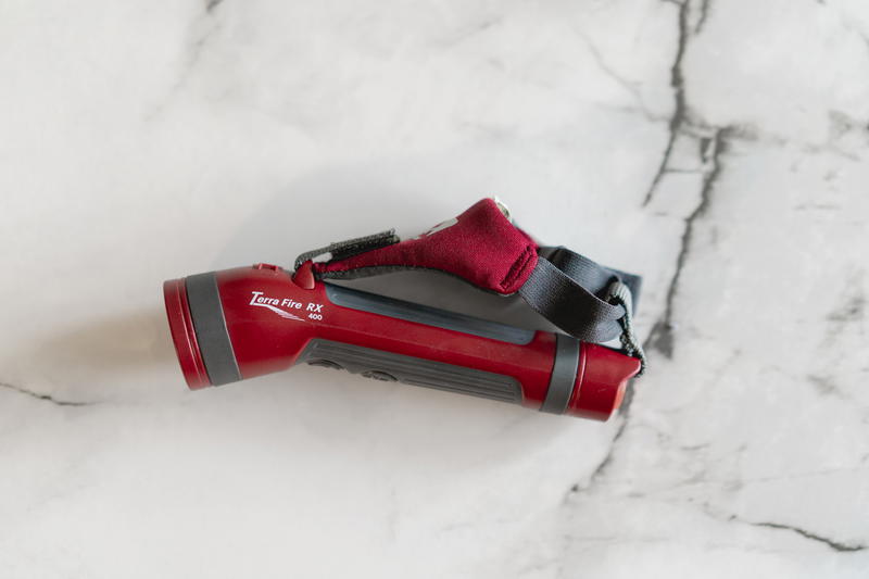A red flashlight on a marble surface.