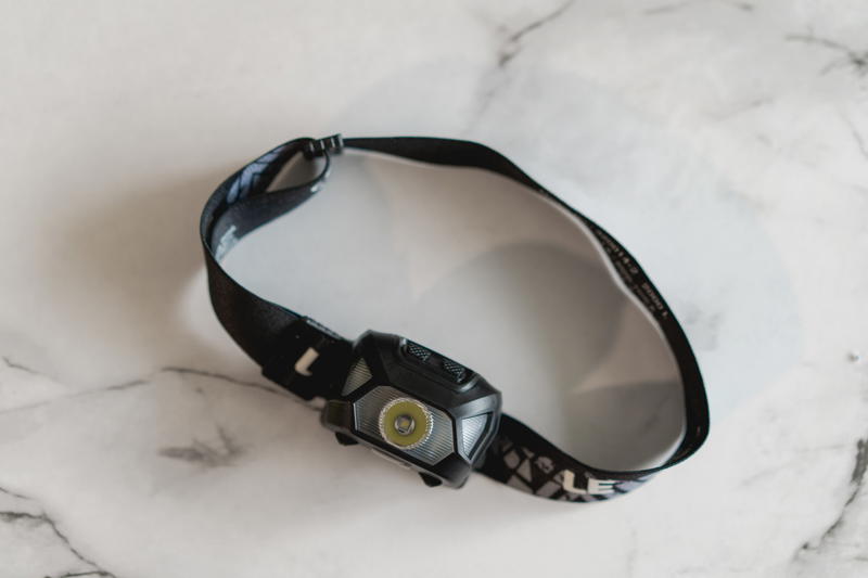 A black headlamp on a marble surface.