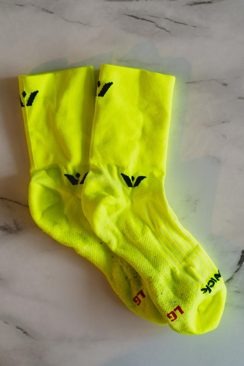 A pair of yellow socks with black logos on them.