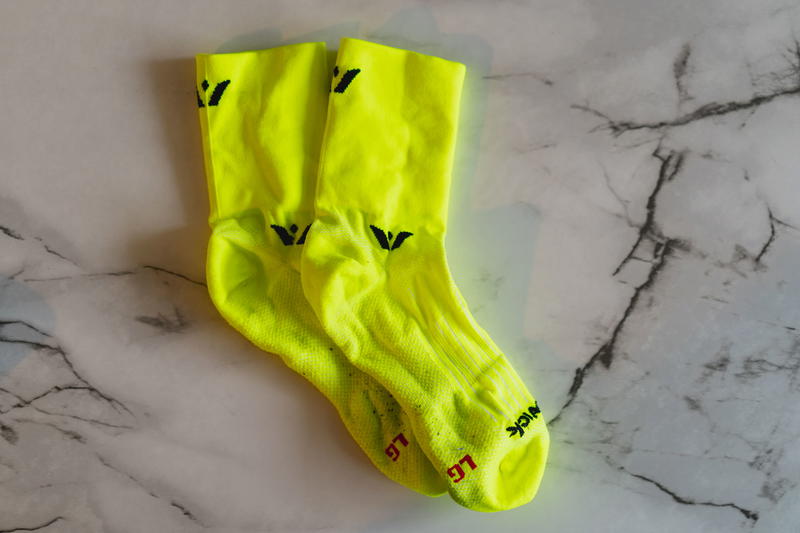 A pair of yellow socks on a marble table.