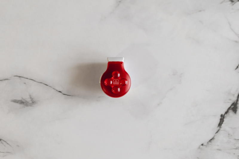 A small red object sitting on a marble surface.