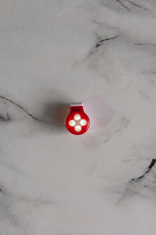 A small red button on a marble surface.
