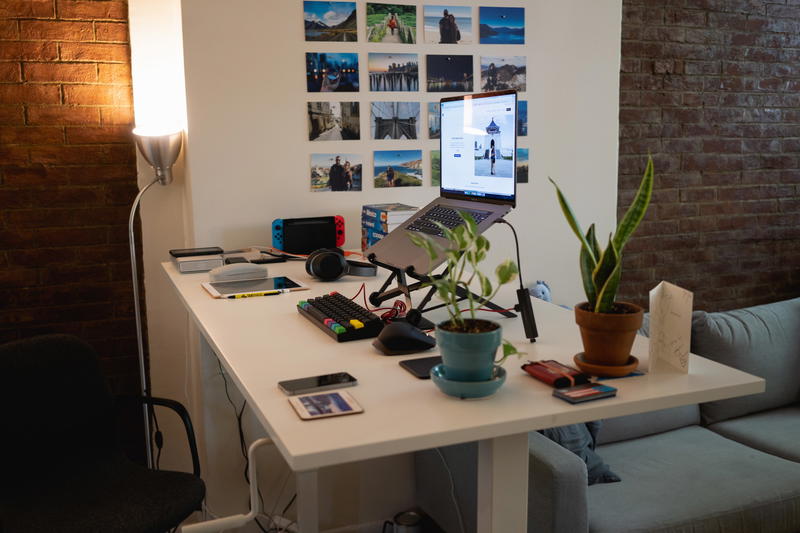 Home office set up with a standing desk, plants and photography decorations