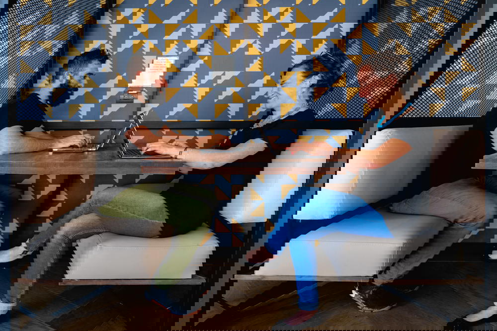 Man and women working at a shared desk in a coworking space in Medellin